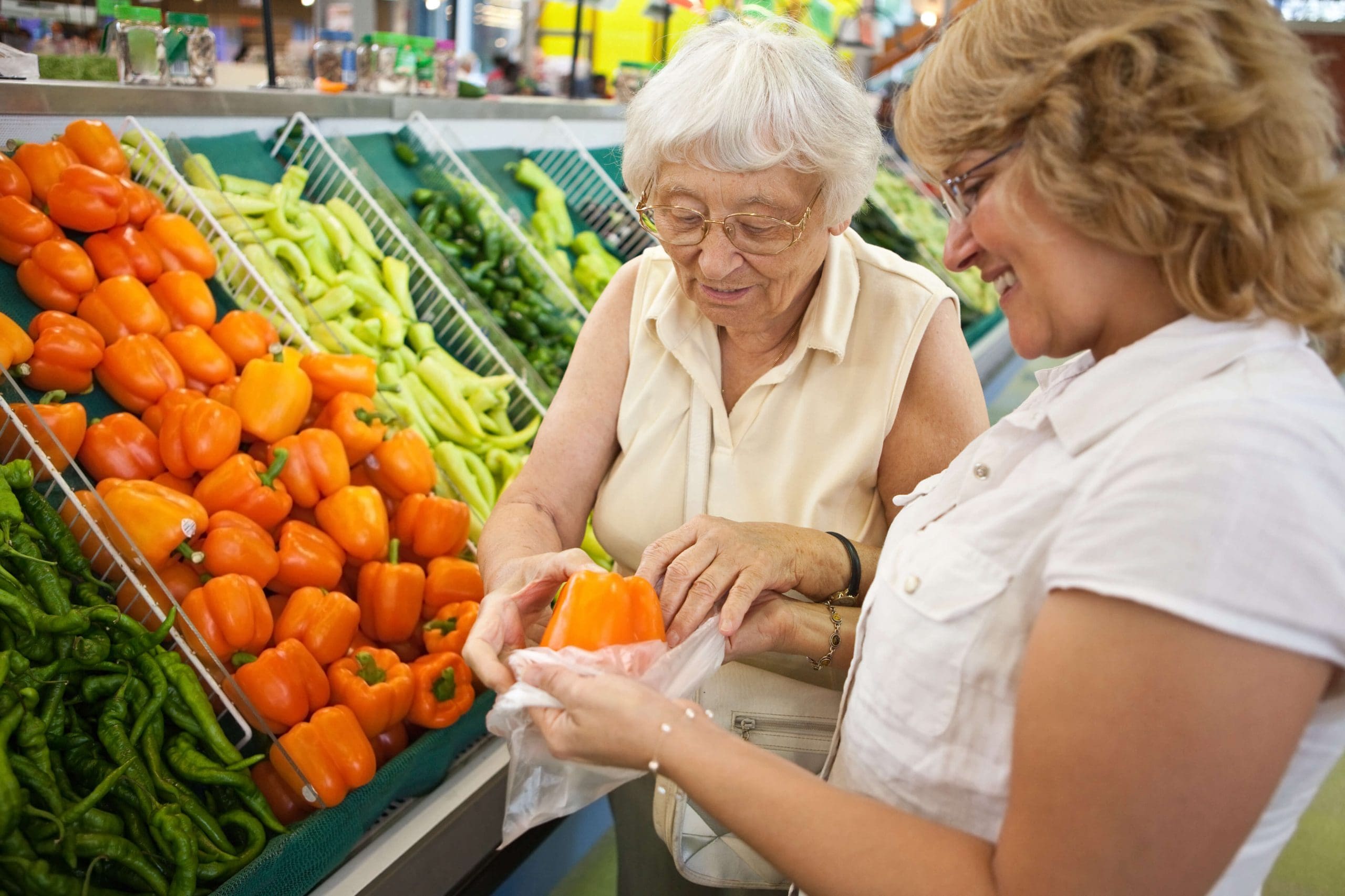 Volunteer lending a helping hand with shopping to a senior (focus on senior)