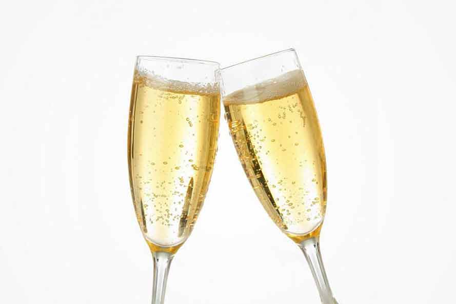 Two full champagne glasses touching together in a "cheers"
