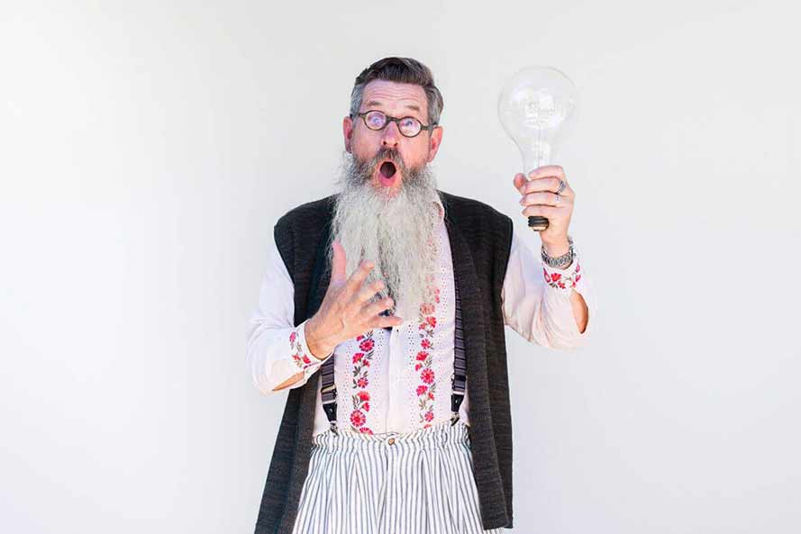 Senior bearded man holding a giant lightbulb