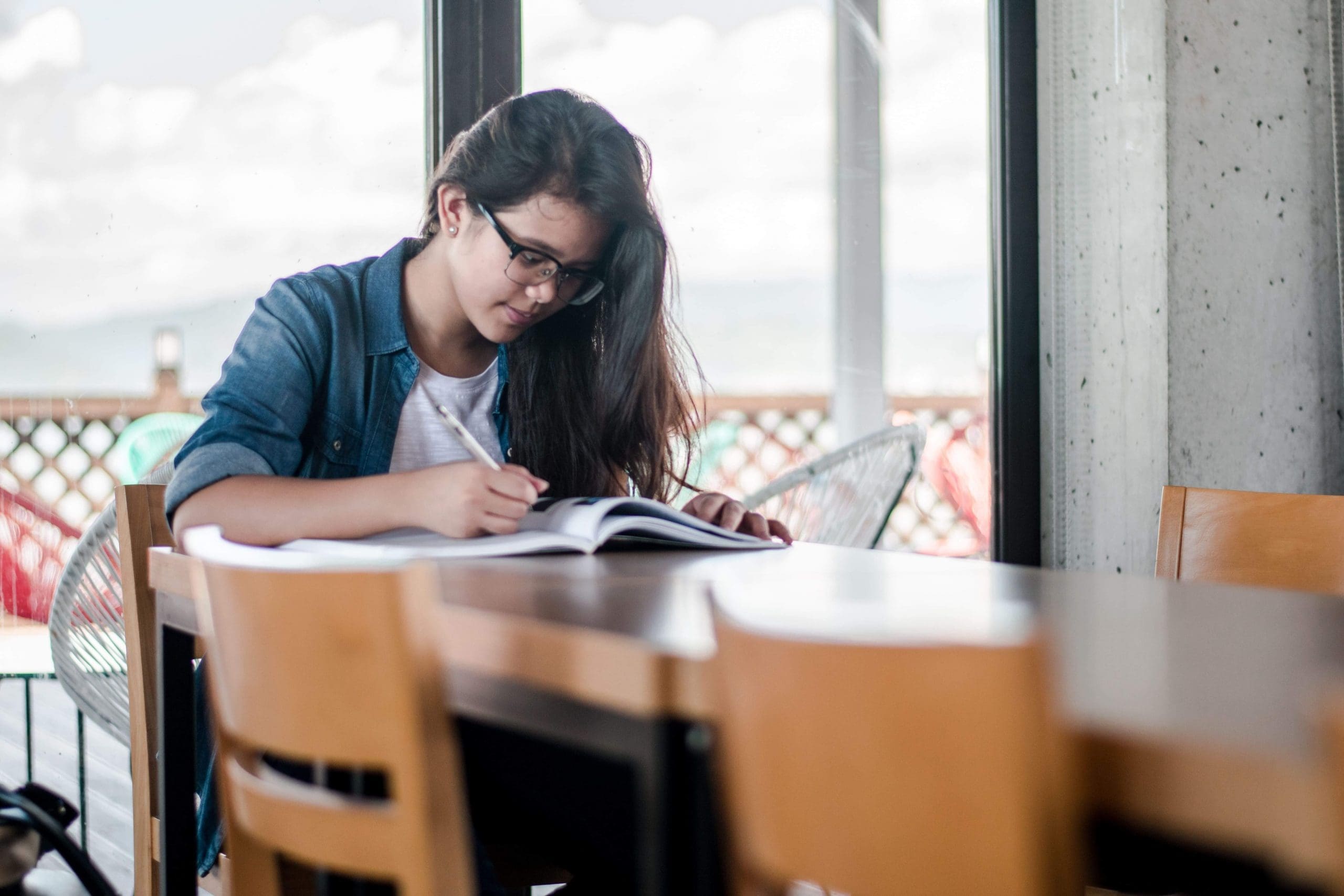 Young woman studying at table with papers