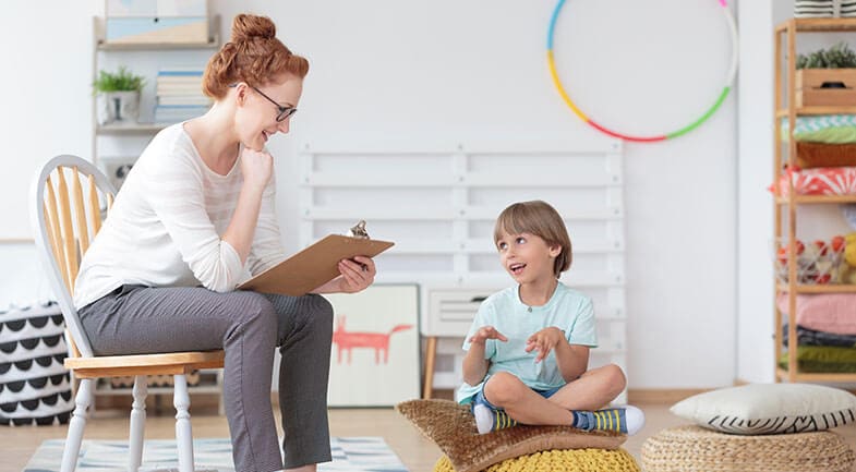 A female therapist talking to a young child in a relaxed setting