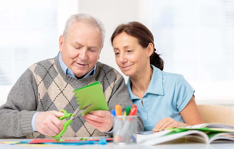 Senior-man-cutting-paper-with-scissors