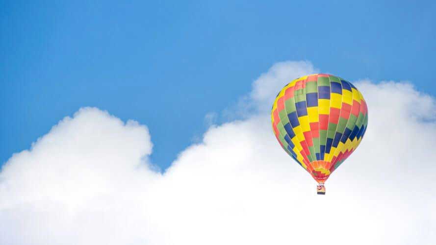 Brightly coloured hot air balloon against blue sky