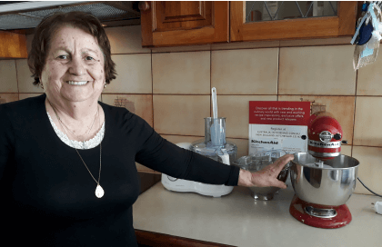 Older woman in kitchen with KitchenAid mixer