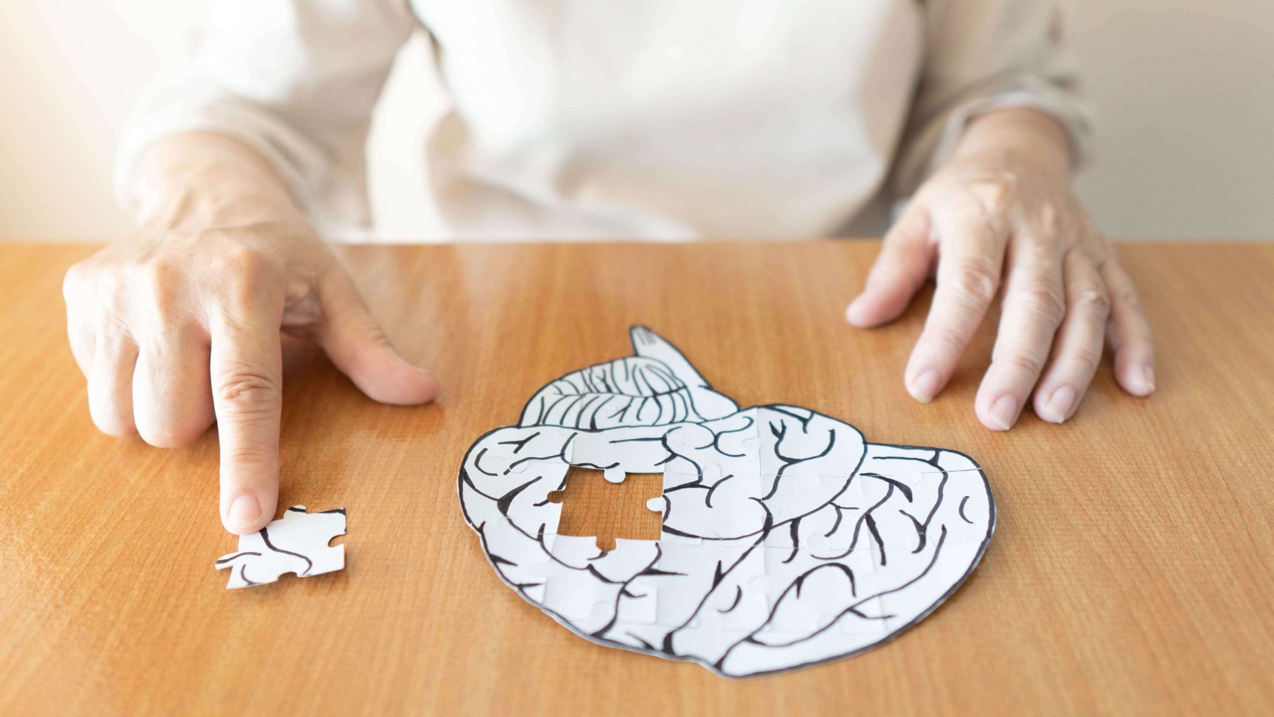 Woman putting together a puzzle of a human brain