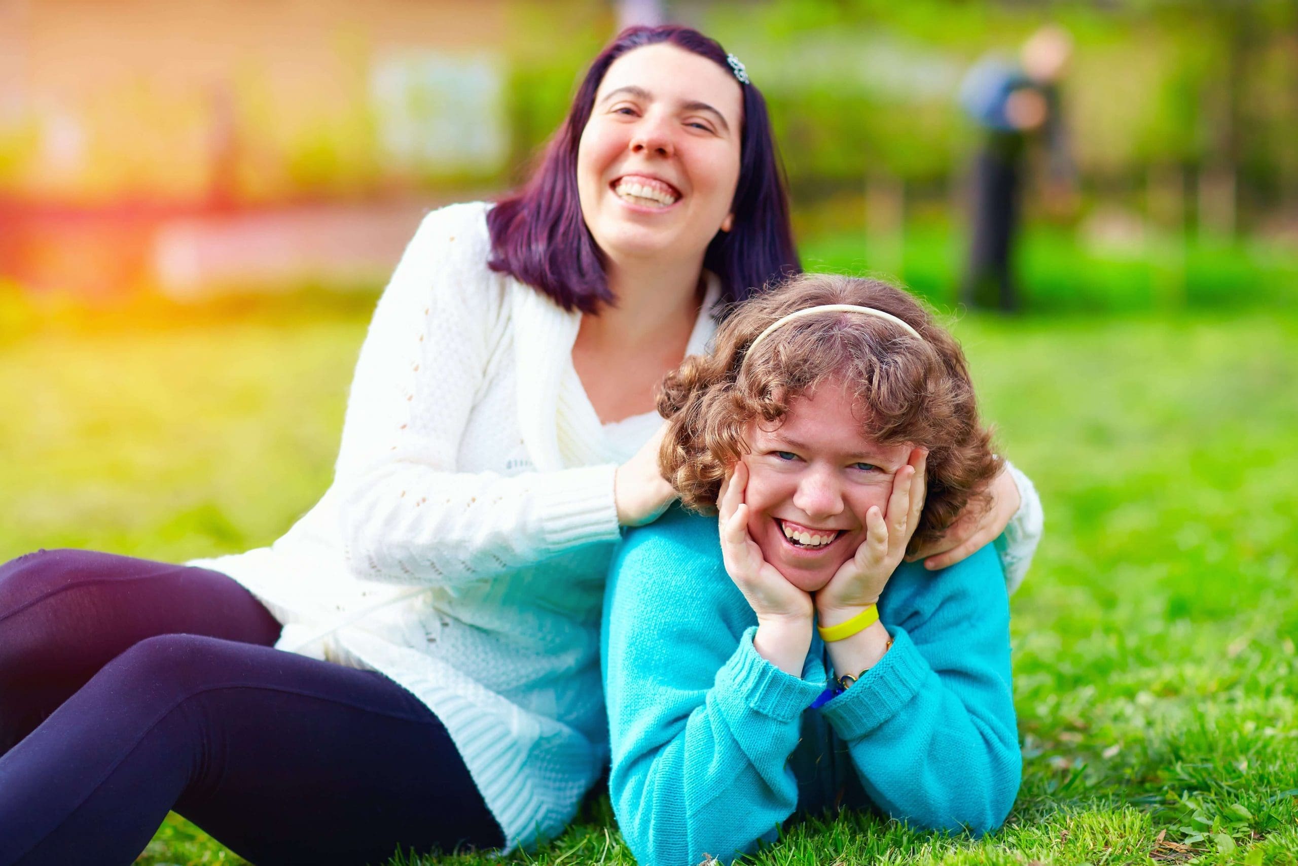 Woman with disability lying on the grass smiling