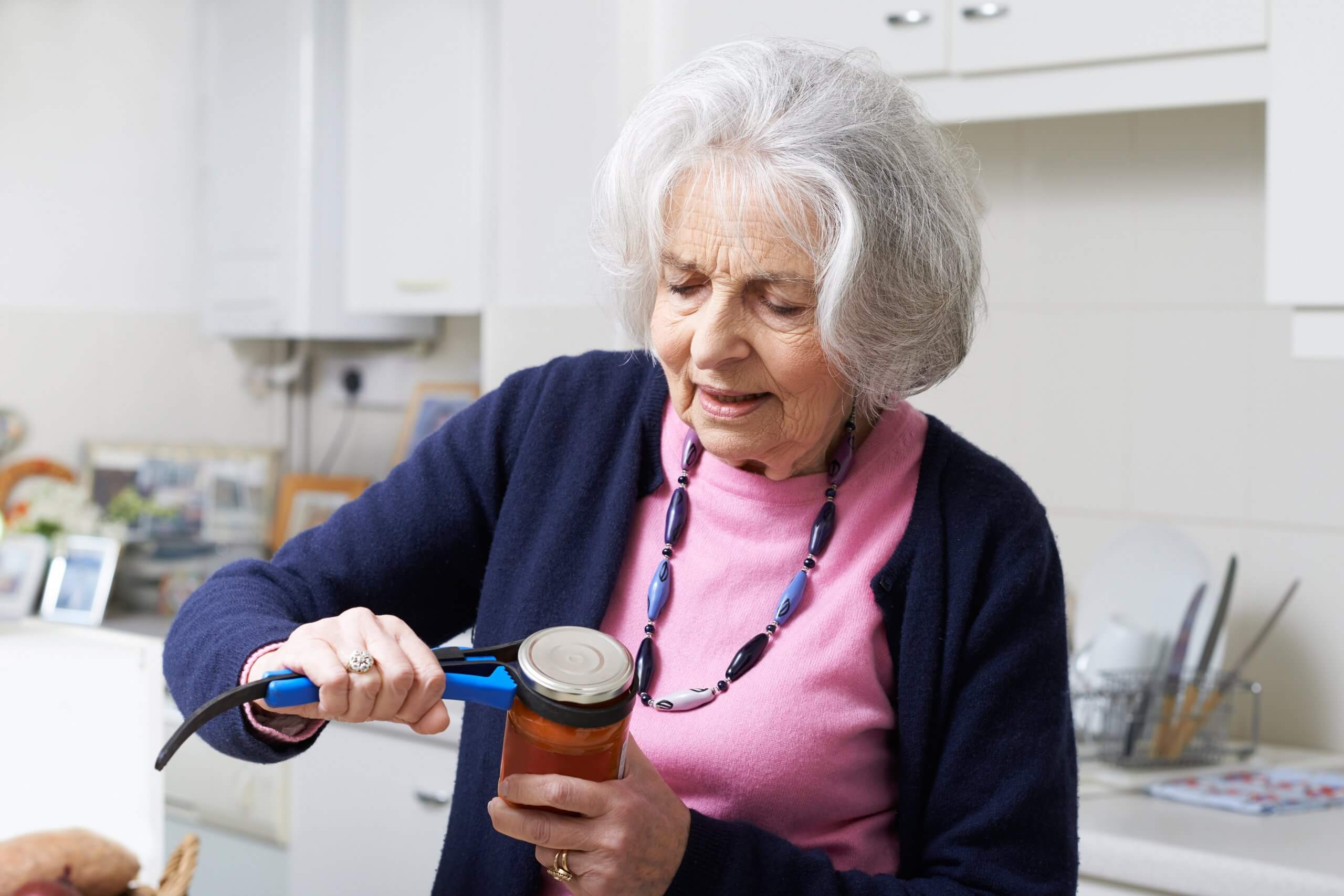 Senior woman using a device to help her open a jar