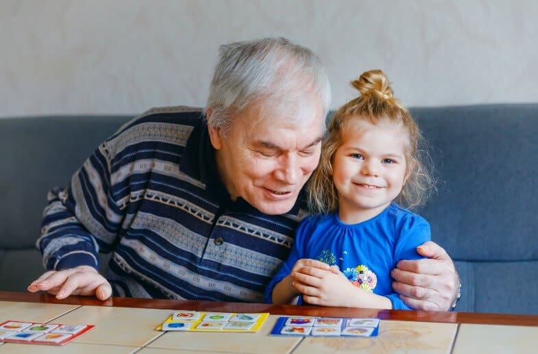 Grandfather and grandaughter playing board game