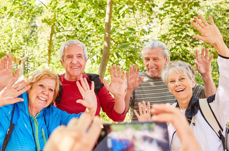 Group of happy seniors waving at the camera