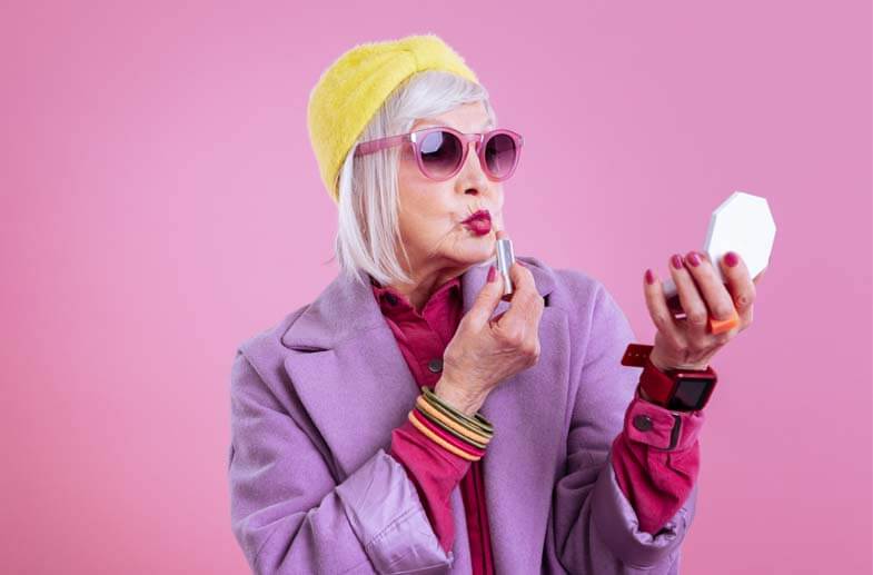 Senior woman dressed up and putting lipstick on
