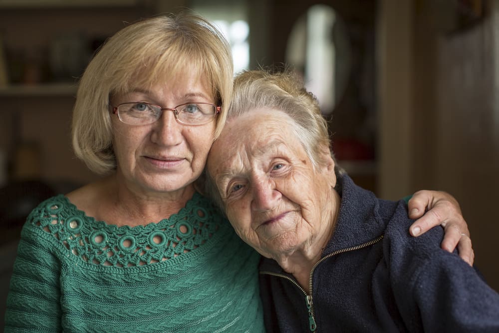 Portrait of an elderly woman with her adult daughter.
